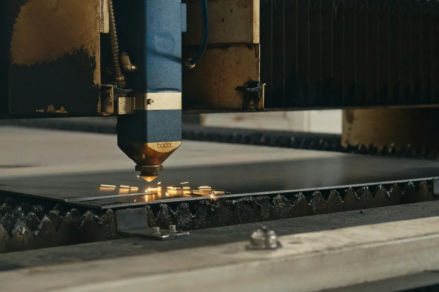 Steel plate being cut on a cutting table, with sparks.